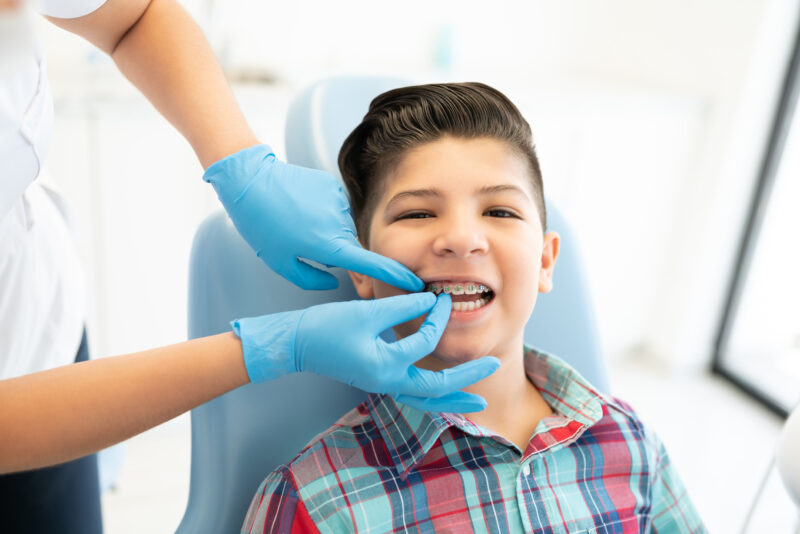 Kid in early orthodontic treatment getting his braces checked
